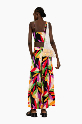 Model wearing a Flowing wide-leg pants with a striking oversized leaf motif in vivid hues.