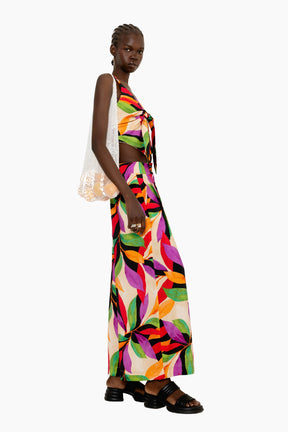 Model wearing a Flowing wide-leg pants with a striking oversized leaf motif in vivid hues.