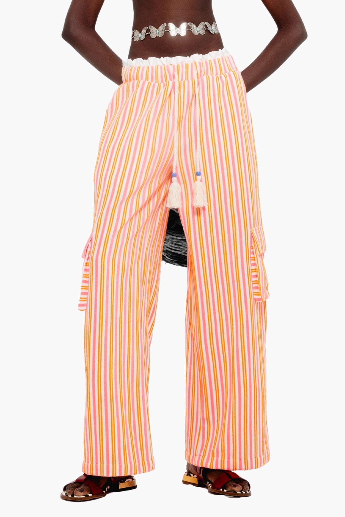 Model wearing a crop top with Wide-leg terry pants with multicolor stripes, elastic waist, tassel ties, and cargo-style side pockets.