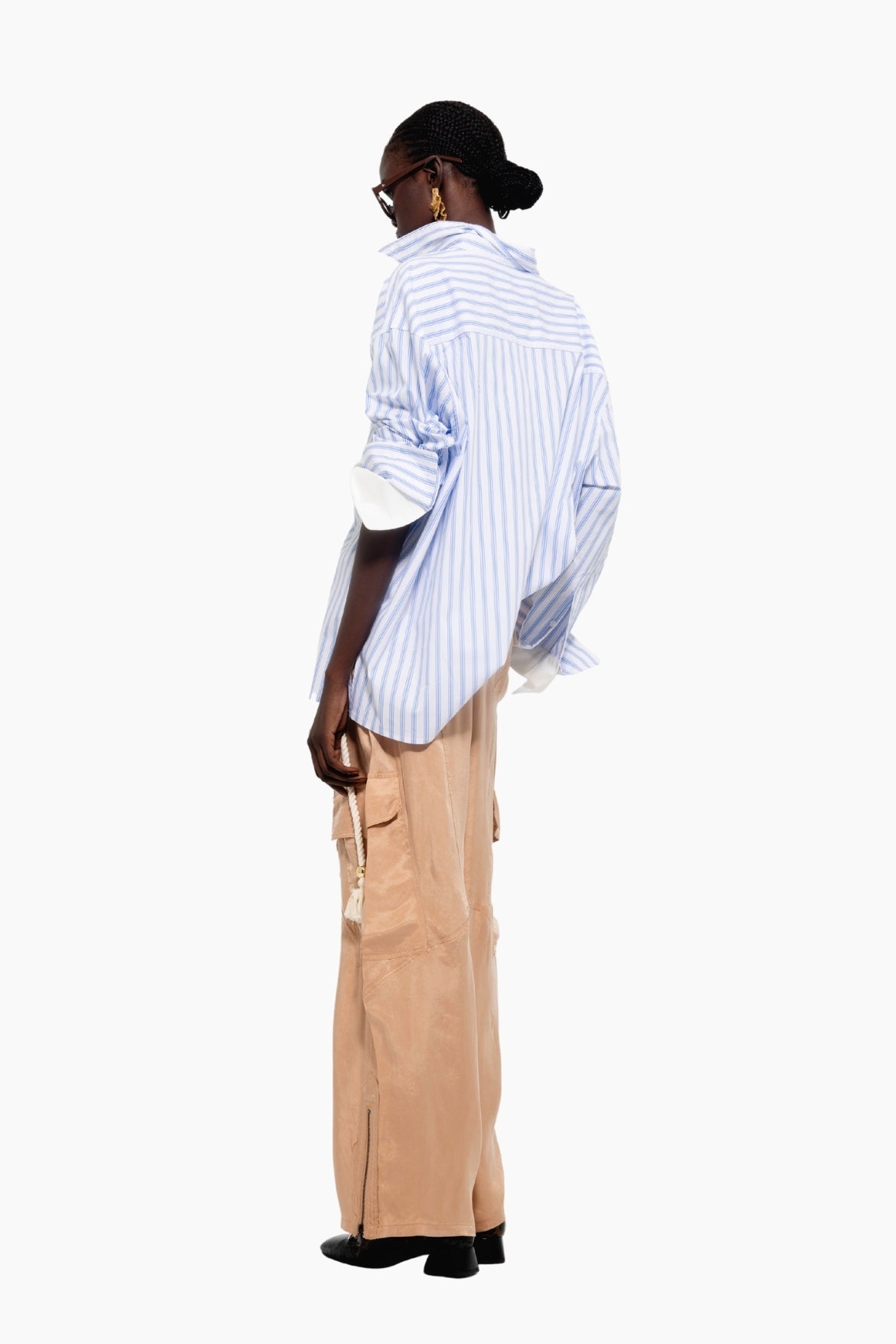 Person wearing a blue striped shirt and beige pants