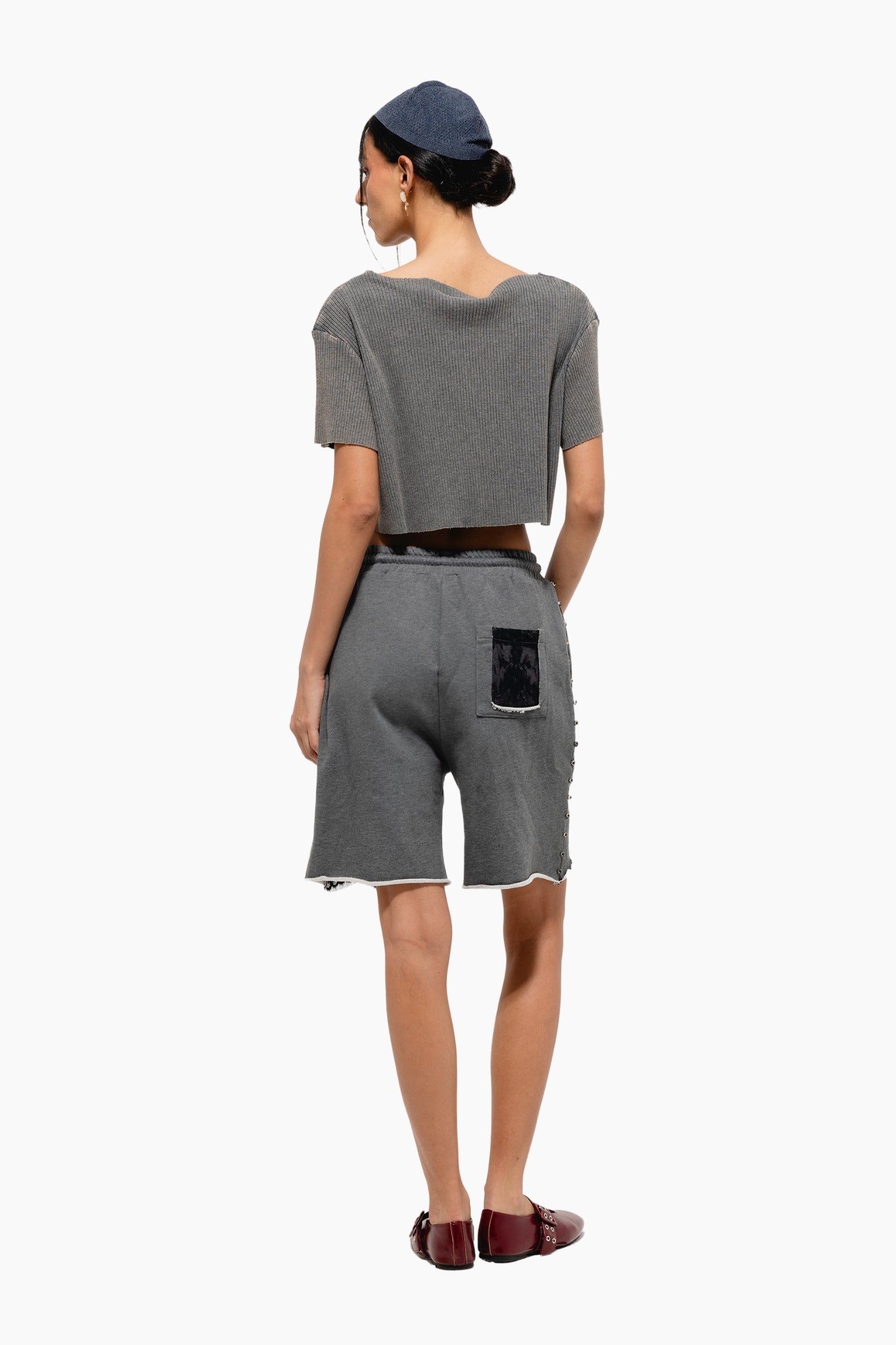 Woman wearing a gray outfit with shorts and a crop top 