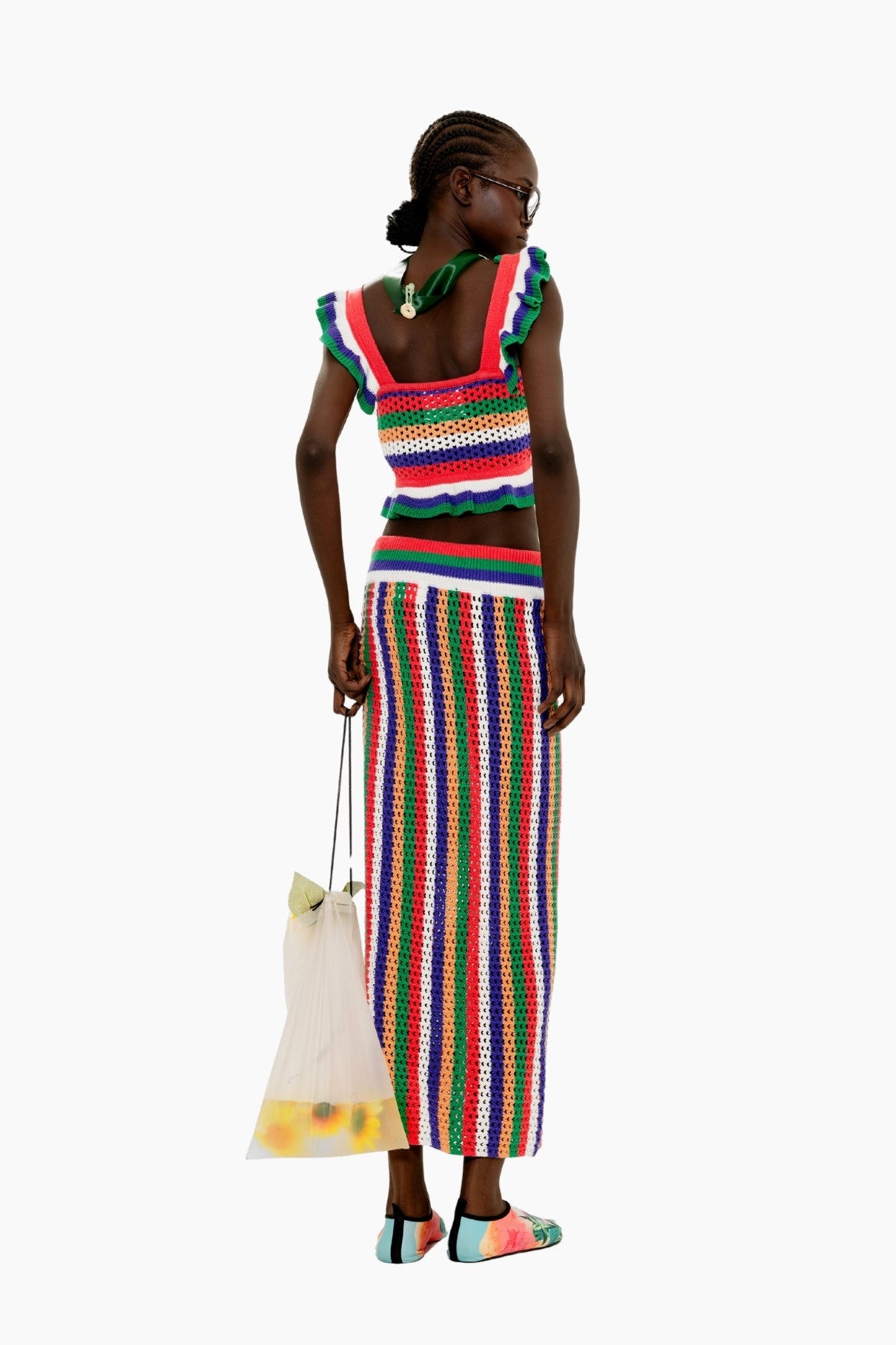 Woman wearing a Colorful striped crochet skirt with a fitted silhouette and tassel detail. with a matching top