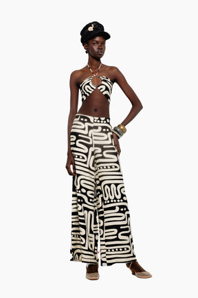 Model wearing a crop top features a bold black-and-white abstract print with a halter neck and a matching pants 