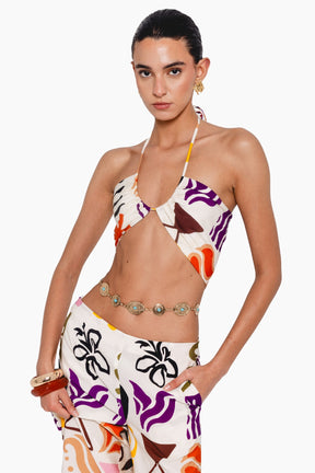 Woman wearing a colorful halter top and skirt 