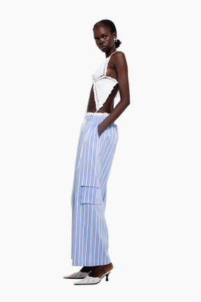 Woman wearing a white top and blue striped pants 