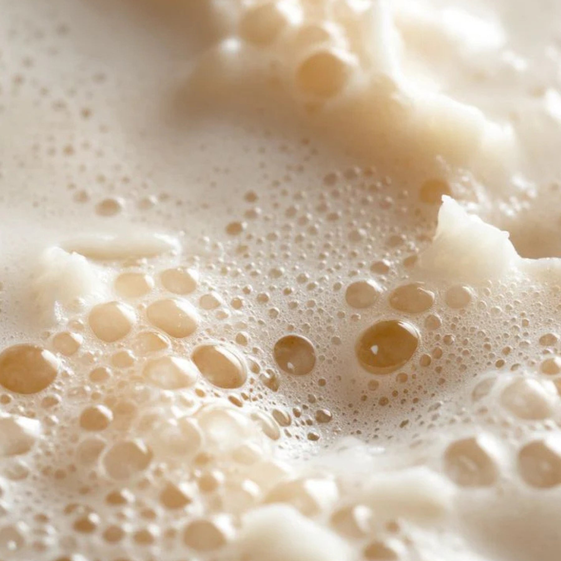 Close-up of frothy beige liquid with bubbles