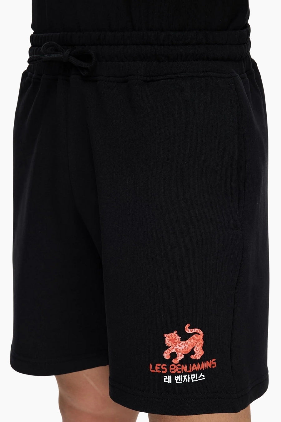 Black shorts with a red tiger logo and text 