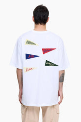 Person wearing a white t-shirt with colorful graphic designs on the back 