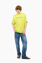 Person wearing a bright yellow t-shirt and blue jeans