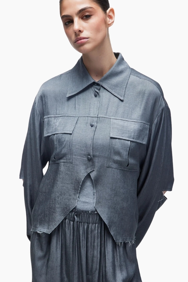 Woman wearing a gray textured shirt with a white background