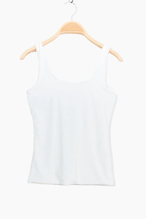 White tank top on a wooden hanger against a white background