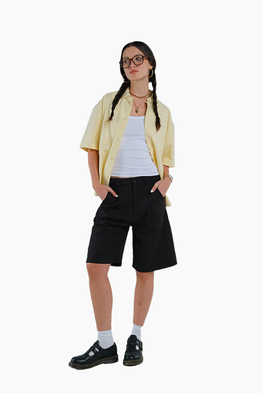 Person wearing a yellow shirt, white top, black shorts, and black shoes 