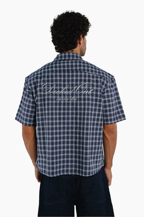 Man wearing a blue and white checkered shirt 
