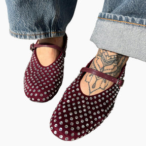 Maroon studded flats worn with blue jeans 