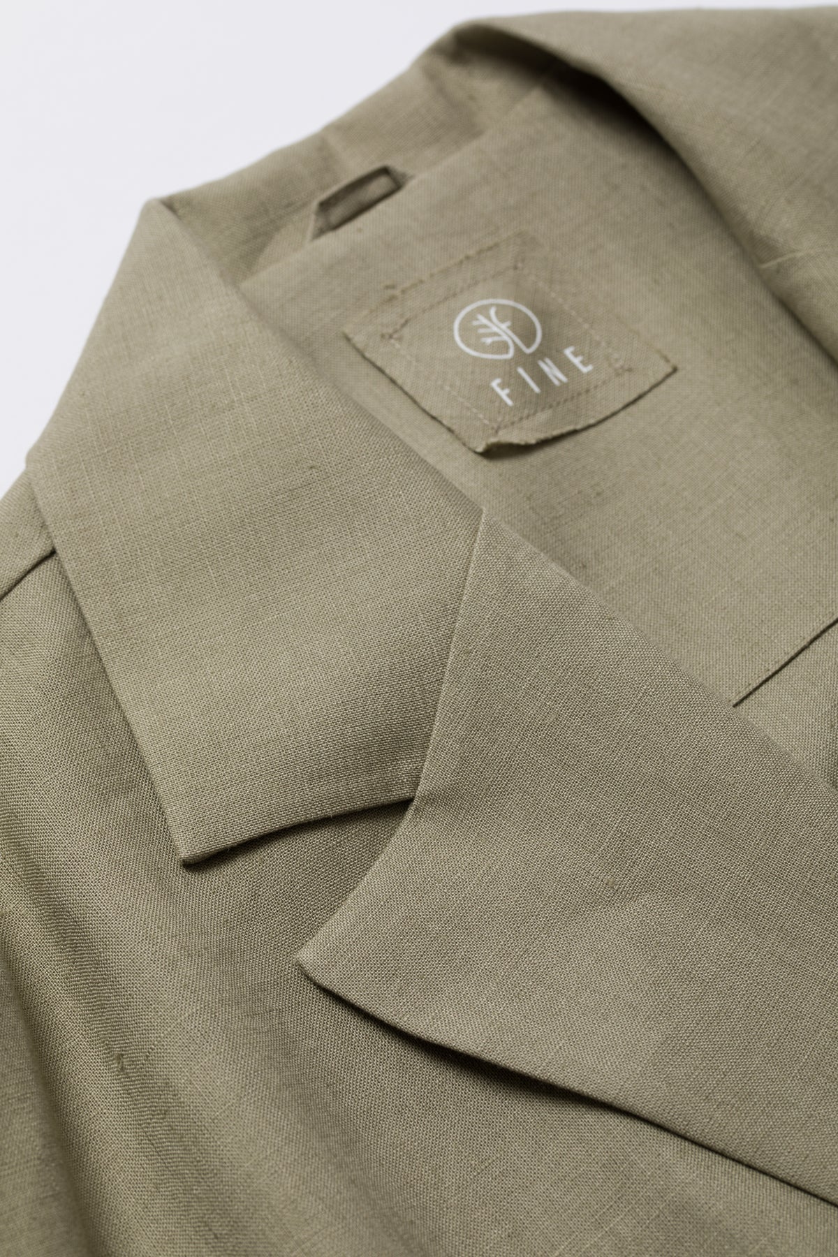 Close-up of a green jacket with a brand logo on a white background