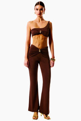 Woman wearing a brown one-shoulder top and wide-leg pants 