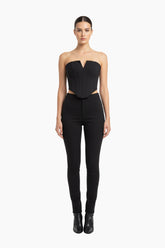 Woman wearing a black strapless top and high-waisted black pants 