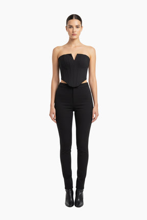 Woman wearing a black strapless top and high-waisted black pants 