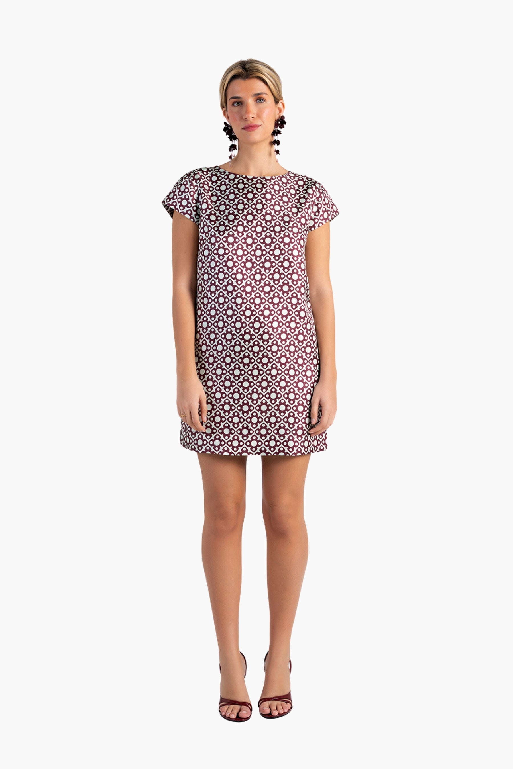 Woman wearing a patterned dress on a white background