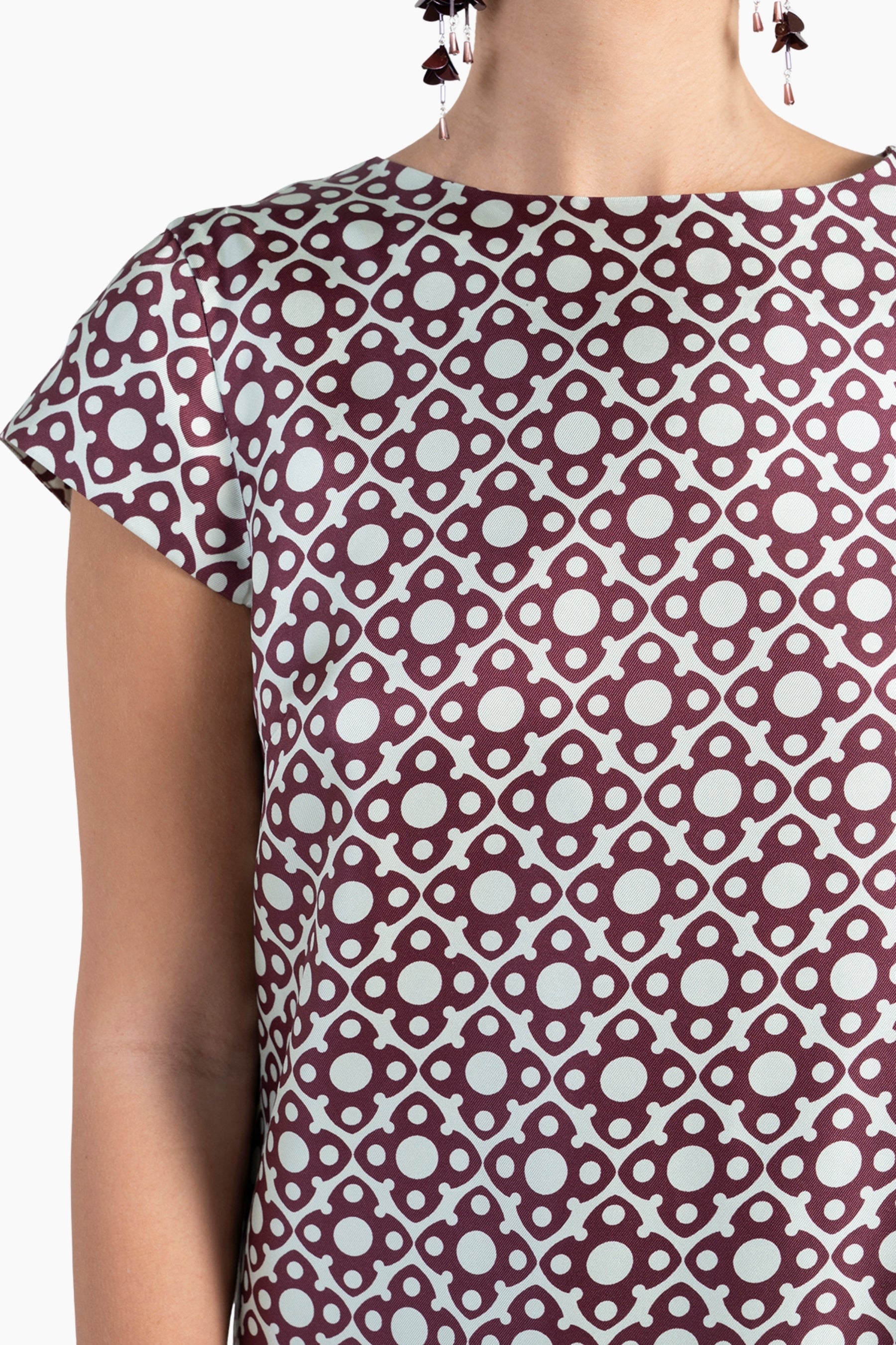 Close-up of a patterned top with a geometric design on a plain background
