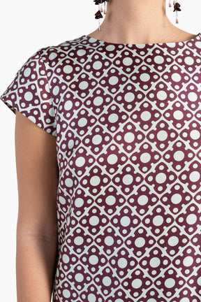 Close-up of a patterned top with a geometric design on a plain background