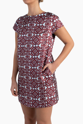 Woman wearing a patterned dress on a white background