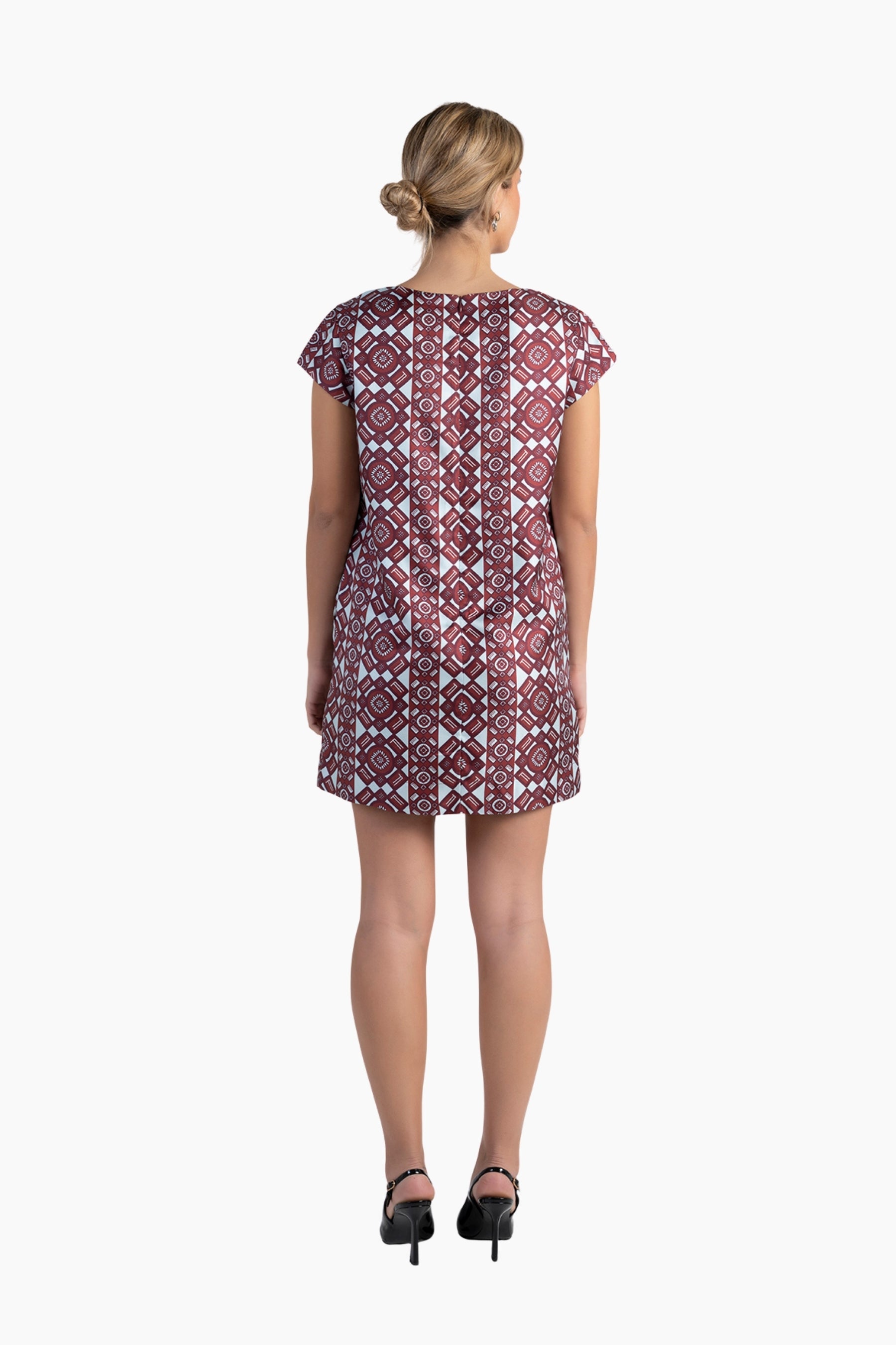 Woman wearing a patterned dress on a white background