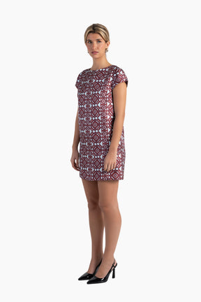 Woman wearing a patterned dress on a white background
