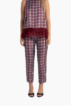 Woman wearing a patterned outfit with a top and pants on a white background