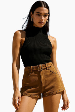 Woman wearing a black sleeveless top and brown shorts with studs 