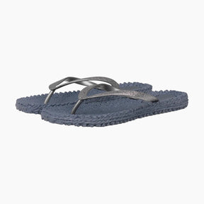 Pair of blue flip-flops with metallic strap on a white background