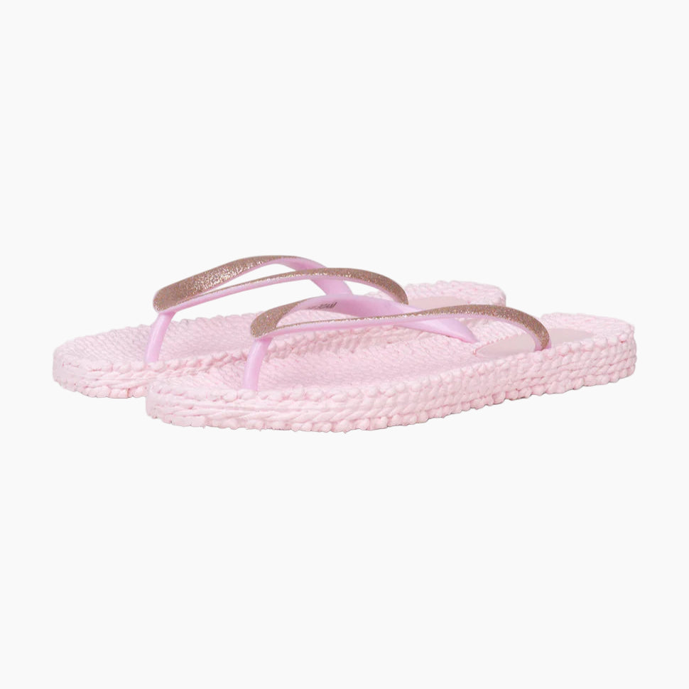 Pair of pink sandals with gold straps on a white background