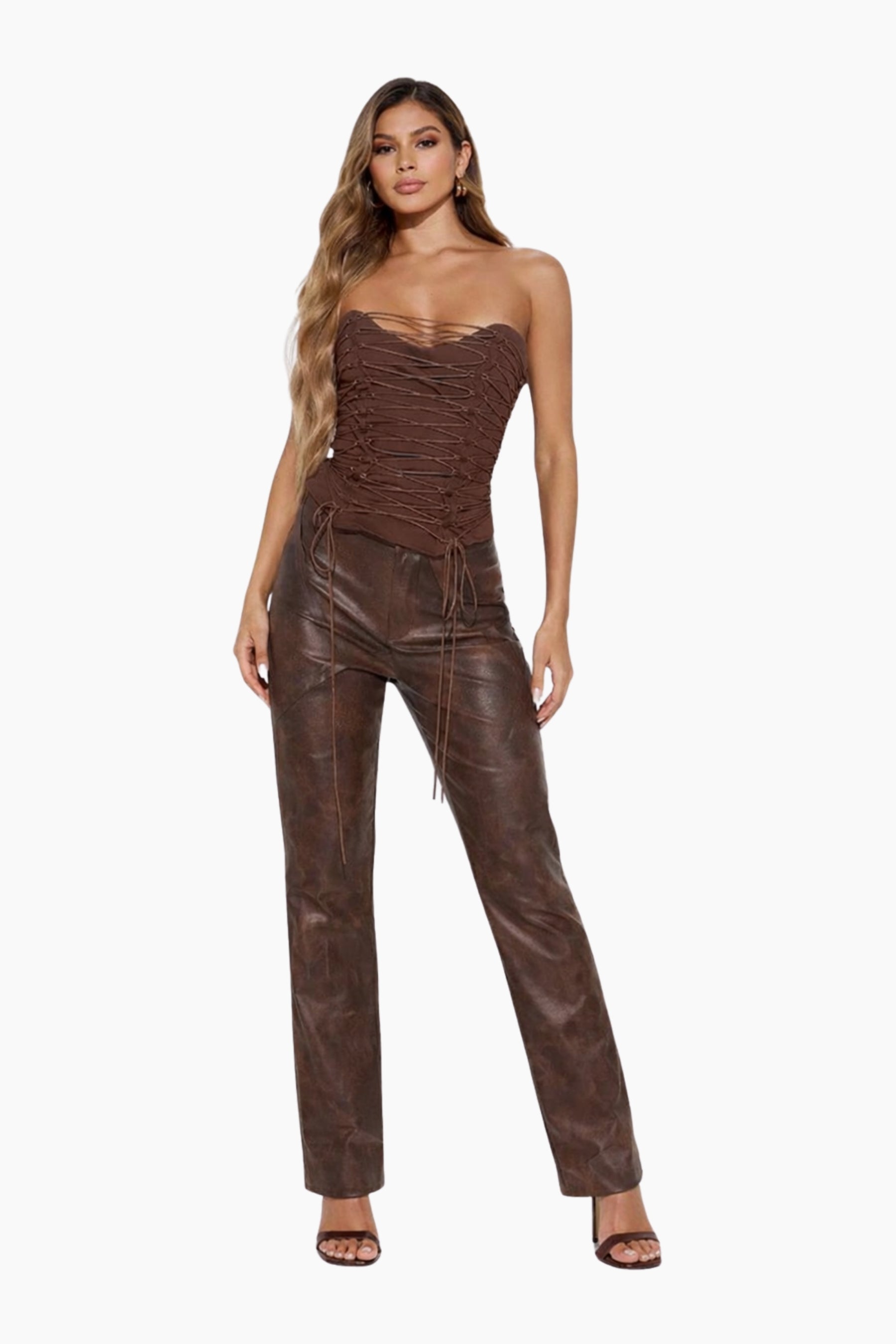 Woman wearing a brown strapless top and leather pants on a white background