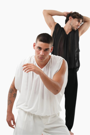 Two men, one in a white sleeveless top and shorts, the other in black