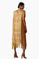 Woman wearing a gold robe with fringe/tassels details 