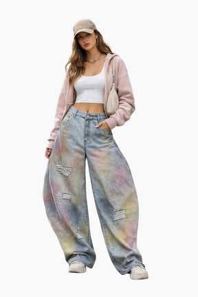 Woman wearing a pink jacket, white top, and tie-dye jeans on a white background