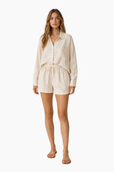 Woman wearing a beige outfit on a white background