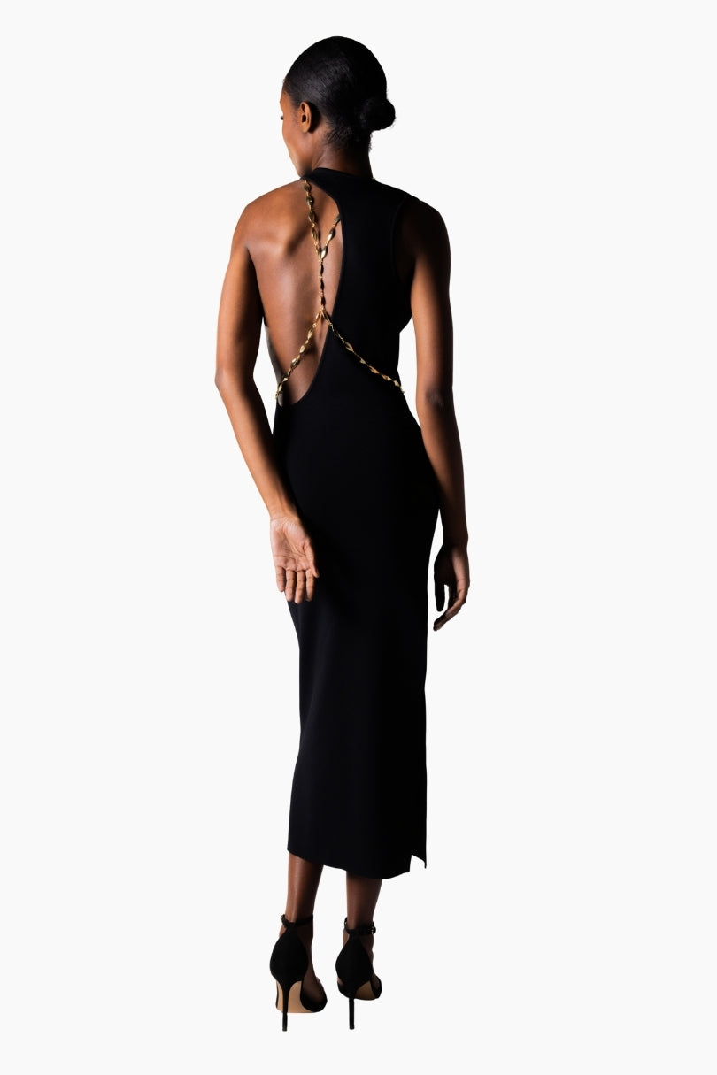a black open back, halter neckline and a thigh-high slit dress. featuring a golden chain on the back