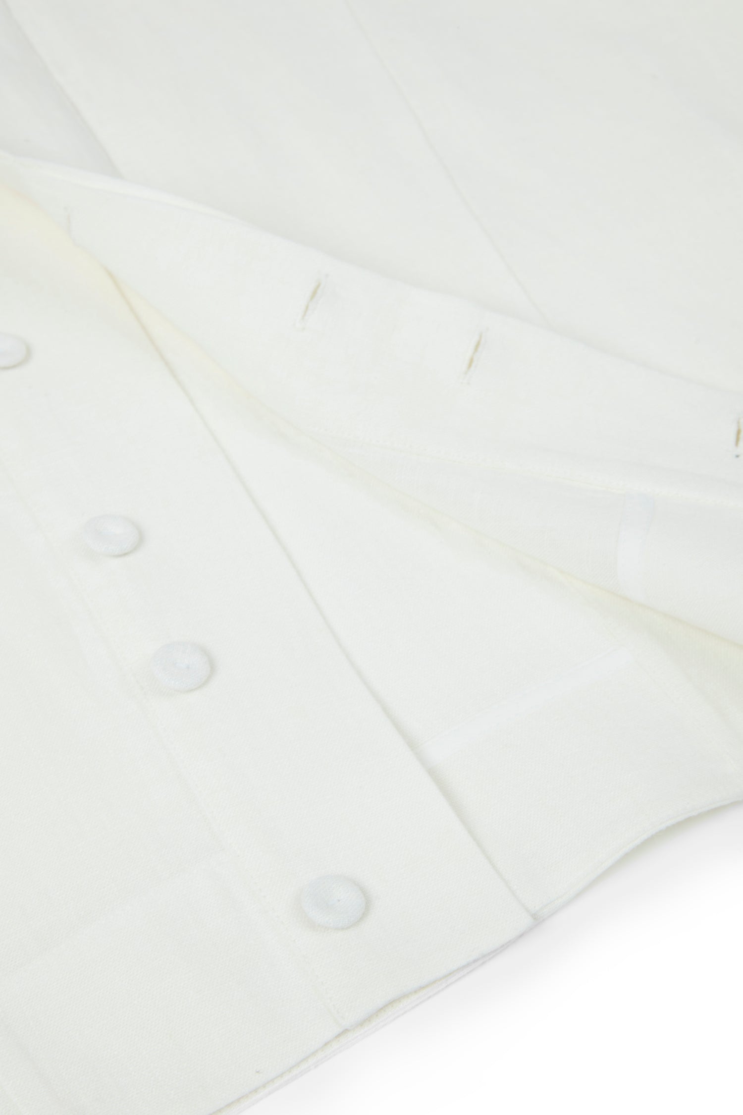 Close-up of a white shirt with buttons on a light gray background