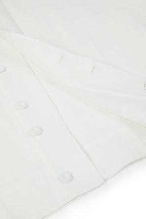 Close-up of a white shirt with buttons on a light gray background
