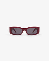 Red sunglasses with dark lenses on a white background