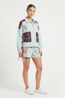 Woman wearing a light blue plaid outfit with a patterned shirt and shorts on a white background