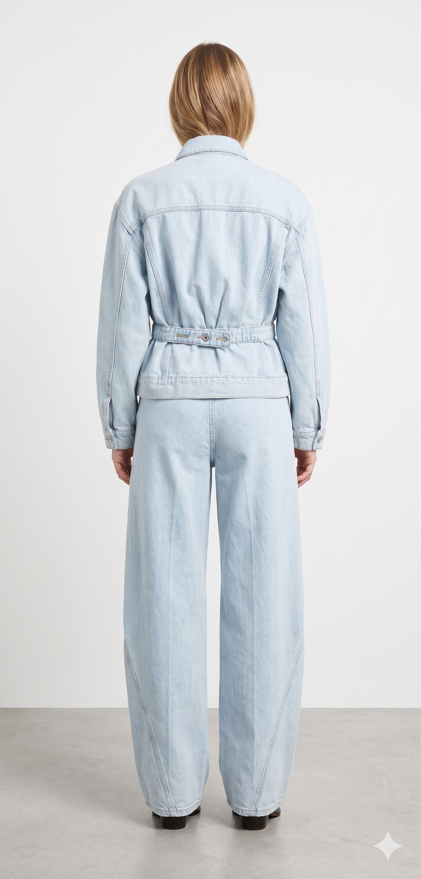 Light blue denim jumpsuit worn by a person on a white background