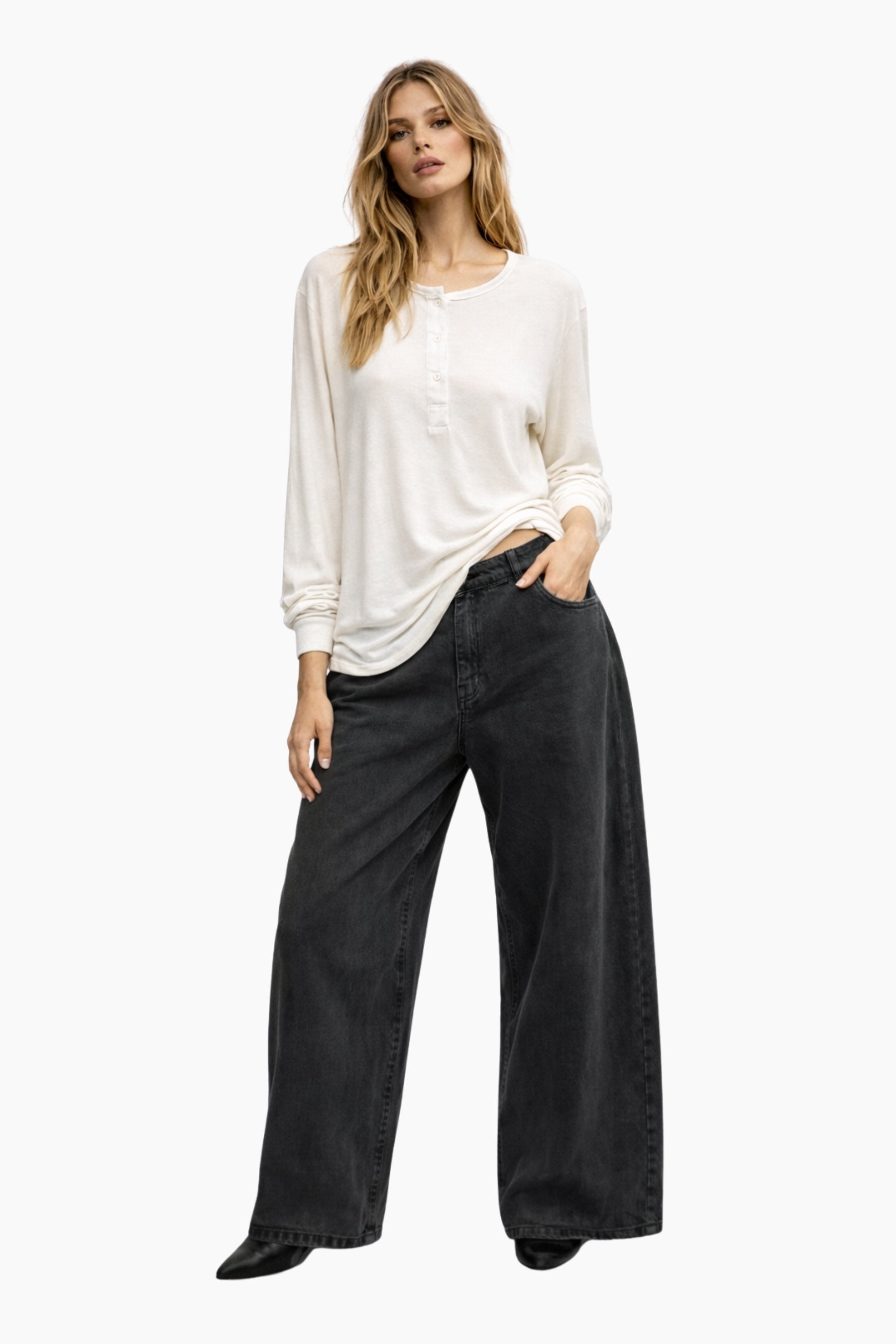 Woman wearing a white top and black wide-leg pants on a white background
