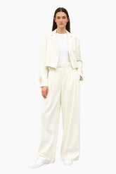 Woman wearing a white suit on a white background