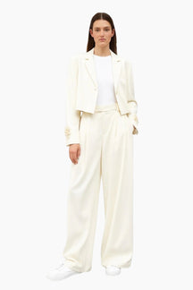 Woman wearing a white suit on a white background