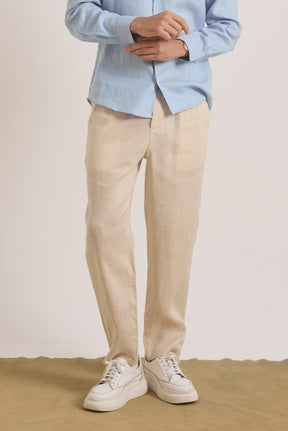 Person wearing a light blue shirt, beige pants, and white sneakers .