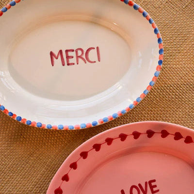 Two ceramic trinket dishes with 'MERCI' and 'LOVE' text 