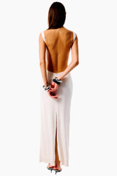 Woman wearing a backless brown top and white skirt 