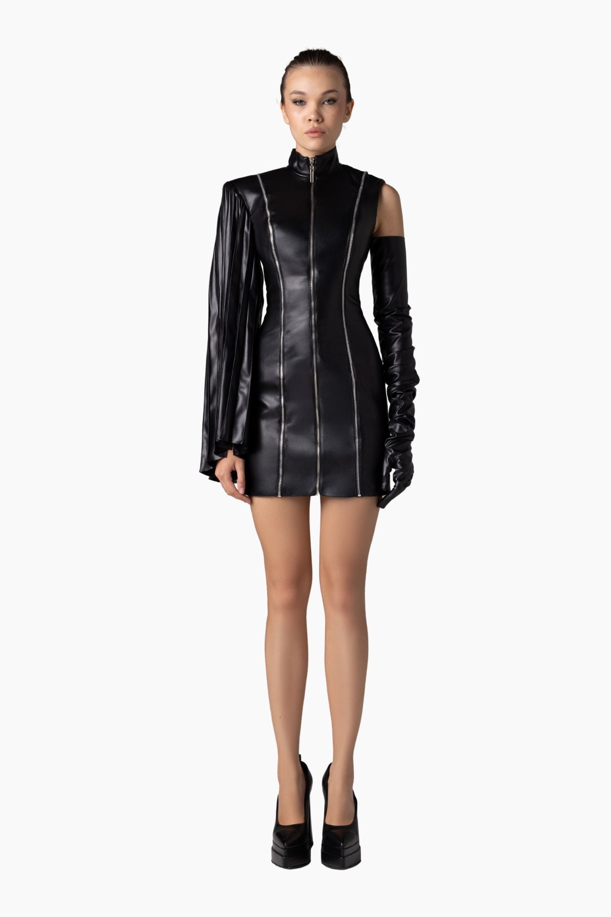 Model wearing a black leather outfit with gloves on a white background
